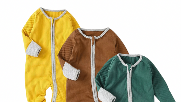 Three baby onesies in yellow, brown, and green on a white background